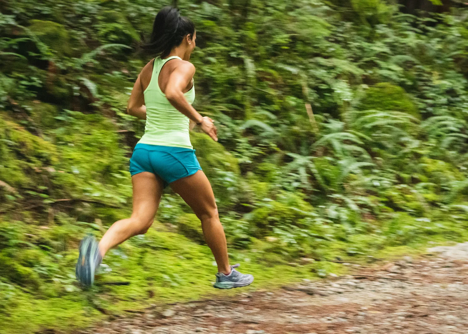 A runner mid-stride on a forest trail